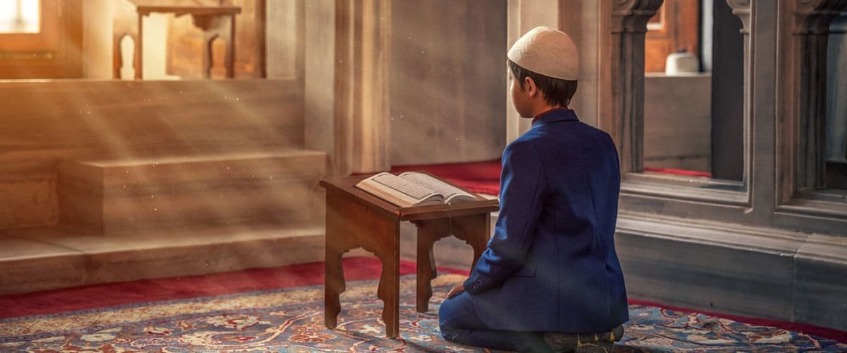 boy reading quran in sunlight